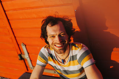 High angle portrait of man sitting against wall