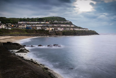 Scenic view of sea by buildings against sky