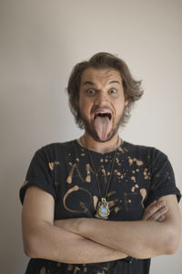 Portrait of a young man sticking out his tongue