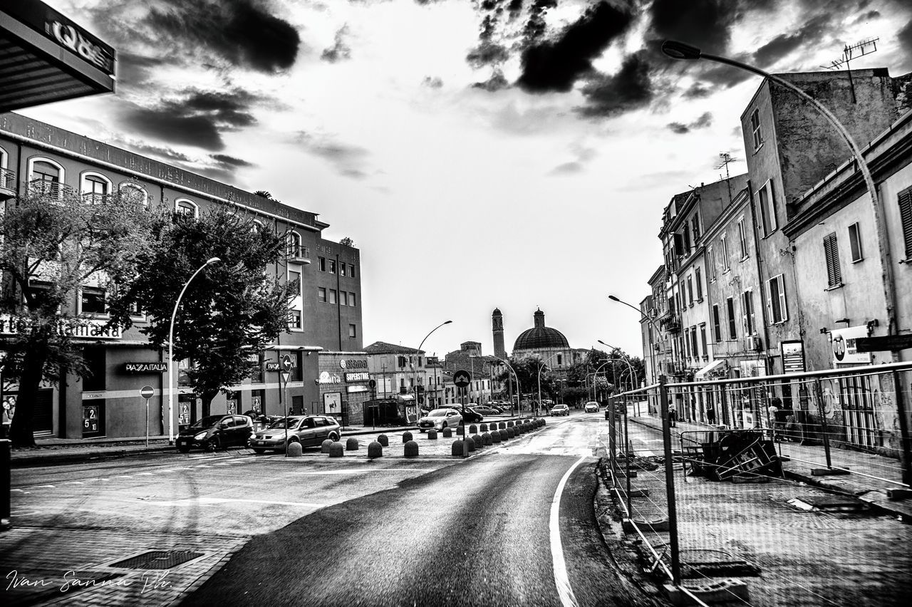 STREET AMIDST BUILDINGS AGAINST SKY IN CITY