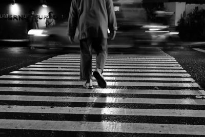 Low section of man walking on road