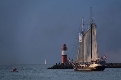 Sailboat sailing on sea against sky