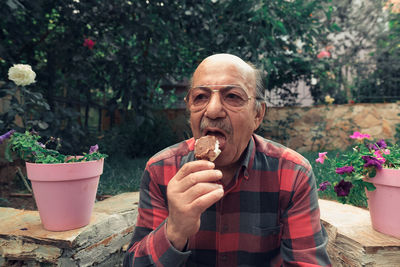 Portrait of man holding potted plant