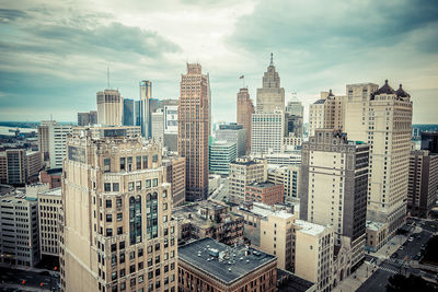 Modern buildings in city against cloudy sky