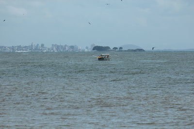 Boat sailing on sea against sky