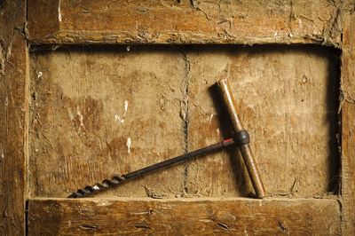 Close-up of gimlet tool on dirty wooden niche