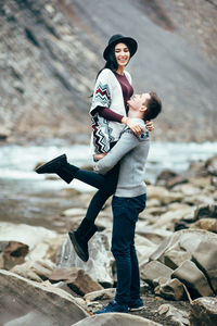 Full length of happy boy standing on rock