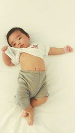 Cute baby girl lying on sofa at home