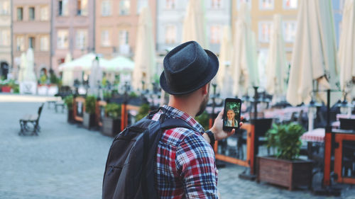 Man wearing hat standing in city