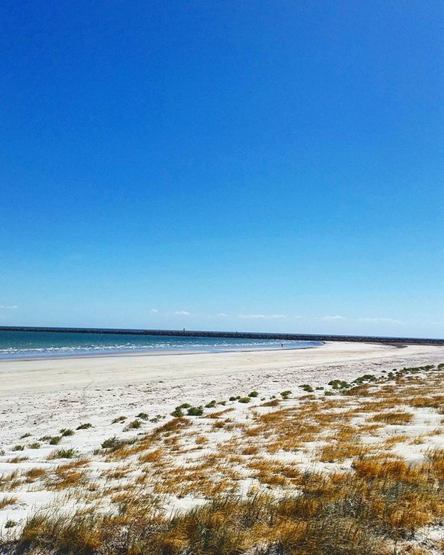 clear sky, copy space, water, sea, blue, beach, tranquil scene, tranquility, scenics, beauty in nature, sand, shore, horizon over water, nature, idyllic, day, remote, non-urban scene, outdoors, coastline