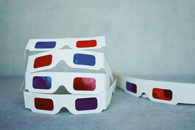 Close-up of 3-d glasses on table against white wall