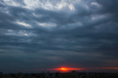 Storm clouds over city during sunset