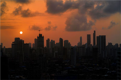 Modern buildings against sky during sunset