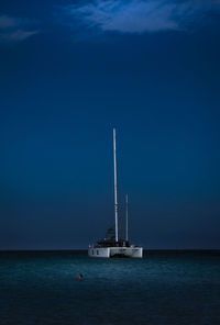 Sailboat sailing in sea against blue sky