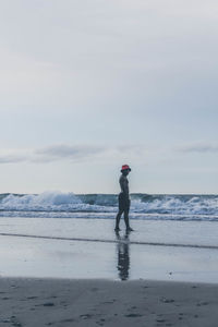 Full length of man standing on beach against sky