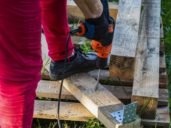 Low section of men working on tree trunk