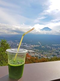 Close-up of drink on mountain against sky