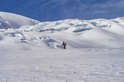 People on snow covered mountain against sky