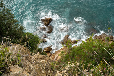 High angle view of waves splashing on rocks