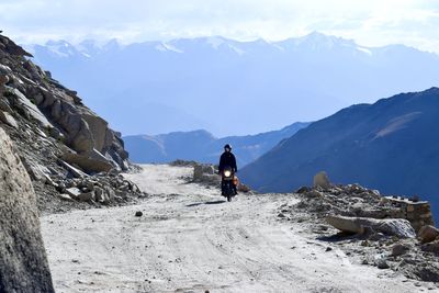  view of man riding motorcycle on mountain