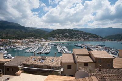 High angle view of residential district by sea against sky