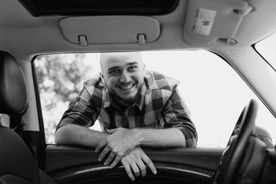 Portrait of smiling man sitting in car