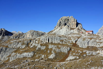 Low angle view of rock formations against clear blue sky