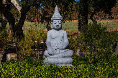 Statue against trees and plants