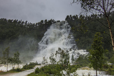 Scenic view of waterfall against sky