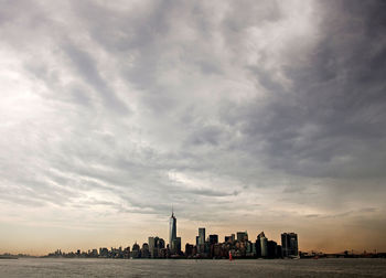 Buildings in city against cloudy sky