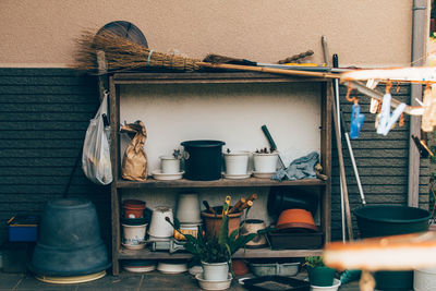 Cleaning equipment and potted plants on old cabinet against wall