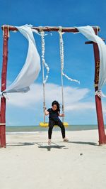 Full length of girl on swing at beach