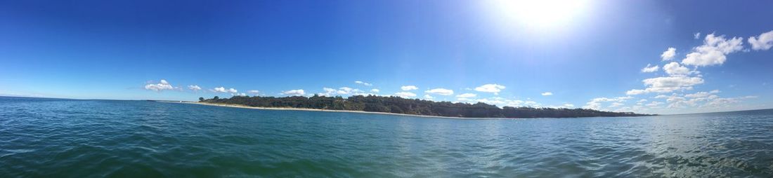 Panoramic view of sea against blue sky