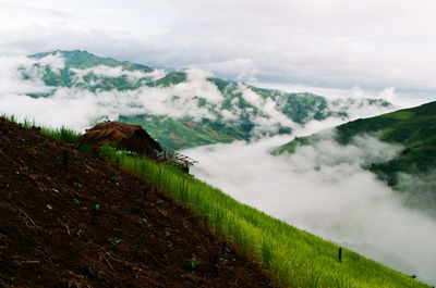 Scenic view of land and mountains against sky