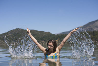 Woman splashing water in lake