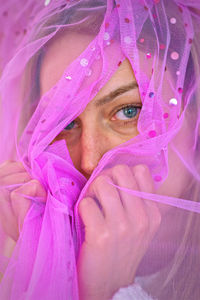 Portrait of a beautiful girl with blue eyes wrapped in pink clothing