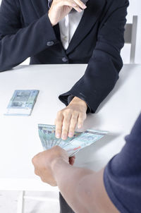 Midsection of couple holding hands on table