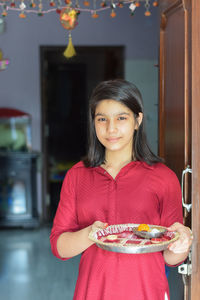 Portrait of a smiling young woman holding ice cream