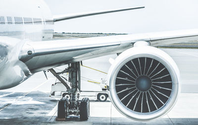 Close-up of airplane on airport runway against sky