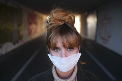 Portrait of woman wearing mask standing in basement