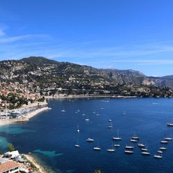 Scenic view of sea and mountains against blue sky