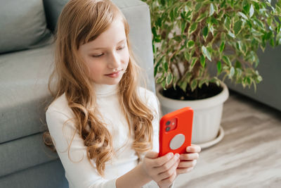 Child sitting on the floor with a smartphone