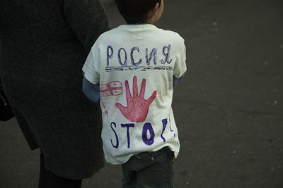 Rear view of boy standing by text