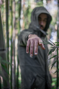 Hand pointing towards the camera with a blurry background