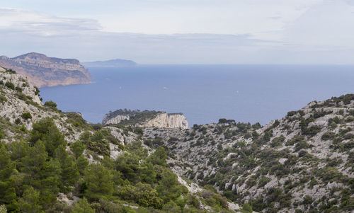 Scenic view of sea and mountains against sky