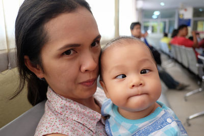 Portrait of woman with baby in hospital