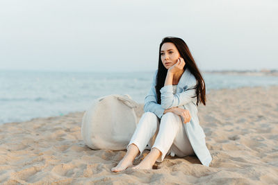 Portrait of smiling young woman sitting on beach