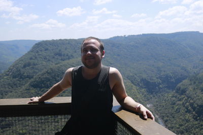 Portrait of man standing on mountain against sky