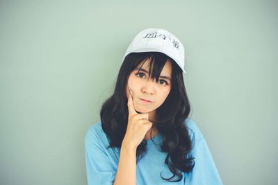 Portrait of young woman against white background