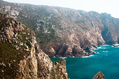 Scenic view of sea and mountains against sky